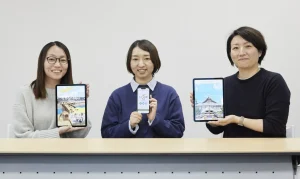 左から福井久美子さん、田口充奈子さん、小林愛恵さん。手元のタブレットとスマートフォンに表示しているのは、左から江戸東京博物館のスマートフォンアプリ「ハイパー江戸博」、江戸東京たてもの園のウェブアプリ「たてもの園ナビ」、同館のオンライン展覧会「Meta Bath（メタバス）～デジタルで見る東京型銭湯～」