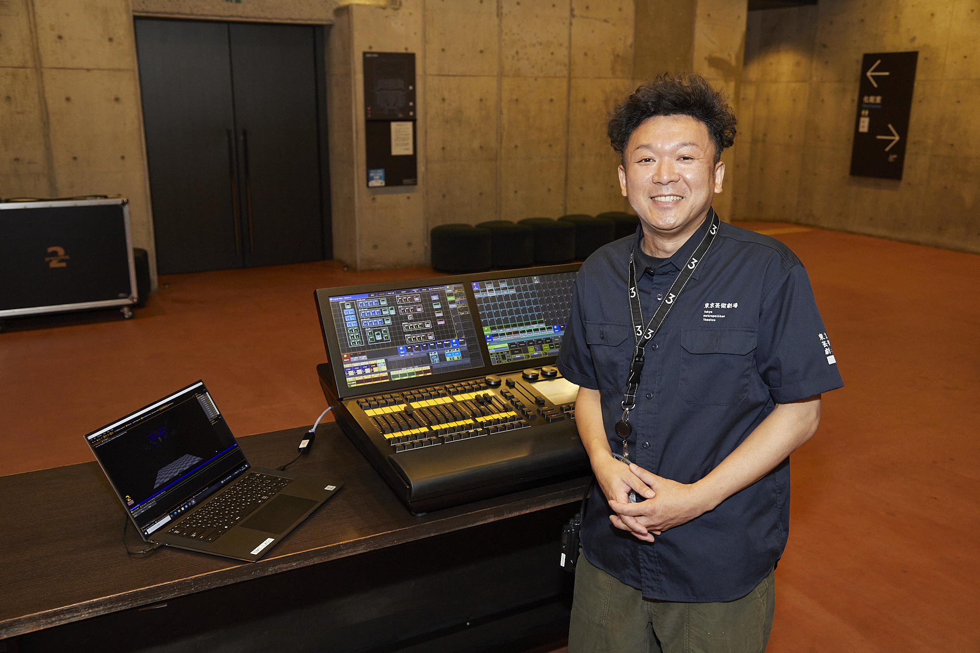 舞台管理担当主任の新島啓介さん。プログラミングした照明デザインを操作するシミュレーターの前で